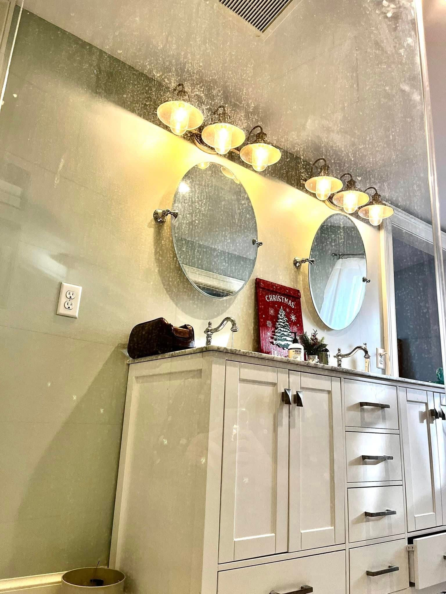 Modern bathroom with double mirrors, stylish lighting, and festive Christmas decor.